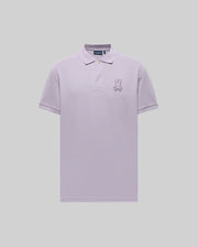The Psycho Bunny MENS PATRICK POLO - MT0100095 is a light purple, short-sleeve 100% cotton polo with a collar, three buttons, and an embroidered cartoon bunny with a bow tie on the left chest, shown on a plain grey background.