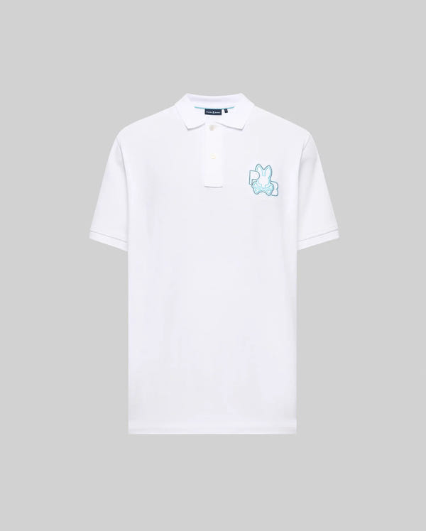 The Psycho Bunny MENS CARLO FASHION POLO (MT0100097) is a white short-sleeve polo with a teal-outlined bunny graphic on the left chest, shown against a plain light gray background.