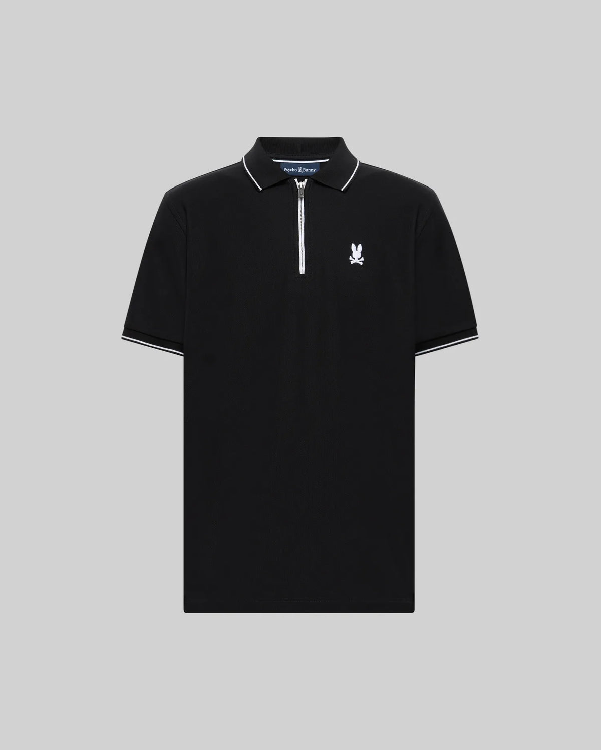 The Psycho Bunny MENS DANE ZIP PIQUE POLO (MT0100103) is a black short-sleeve Pima cotton polo with a zip-up collar, sporty white trim on the collar and sleeves, and a white embroidered Bunny logo on the left chest.