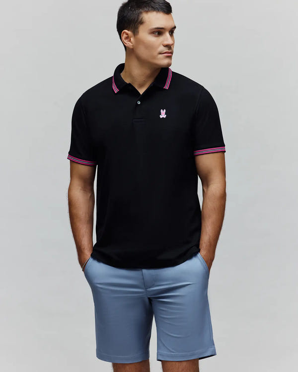 MENS CLARK PIQUE POLO, black classic fit pique polo with a small pink embroidered Psycho Bunny skull logo on the left chest and pink/white striped tipping on the collar and cuffs.