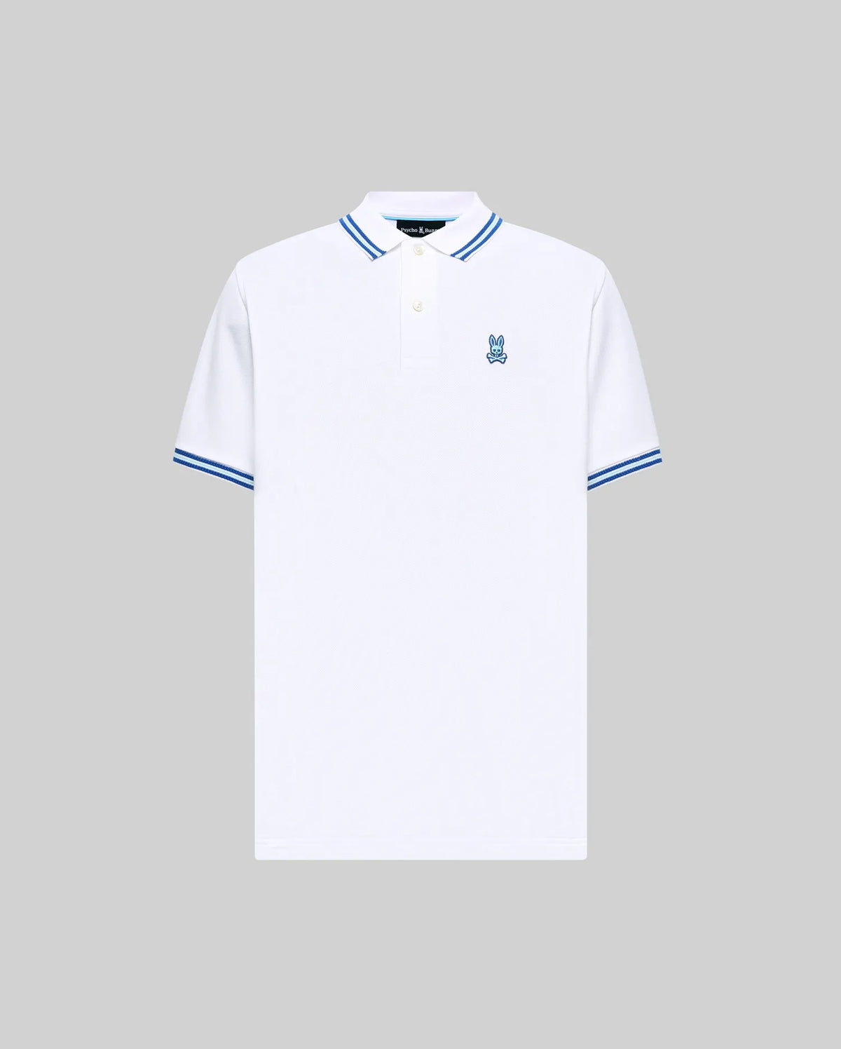 Mens Clark Pique Polo, white classic fit pique polo with blue double-striped collar and cuffs, featuring a small embroidered blue Psycho Bunny skull logo on the left chest.