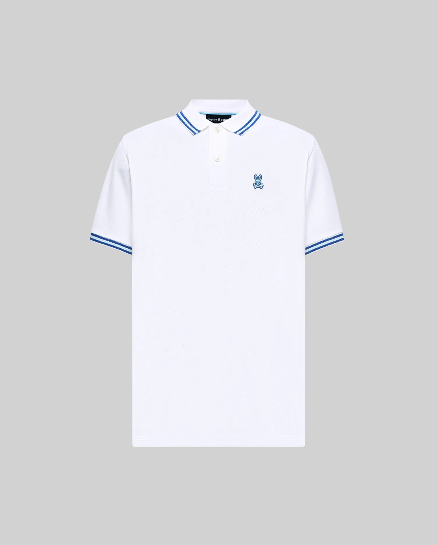 Mens Clark Pique Polo, white classic fit pique polo with blue double-striped collar and cuffs, featuring a small embroidered blue Psycho Bunny skull logo on the left chest.