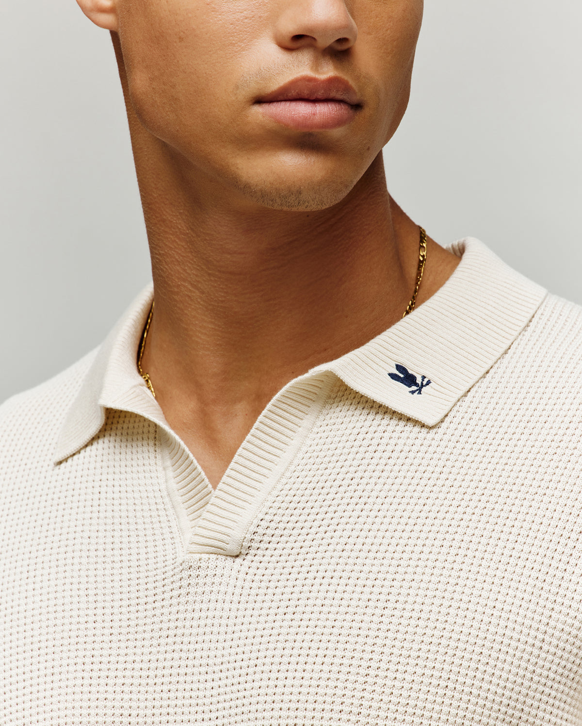 Mens Lochlan Oversized Johnny Collar Polo in cream textured knit, featuring a small embroidered dark blue Psycho Bunny skull logo on the left collar.