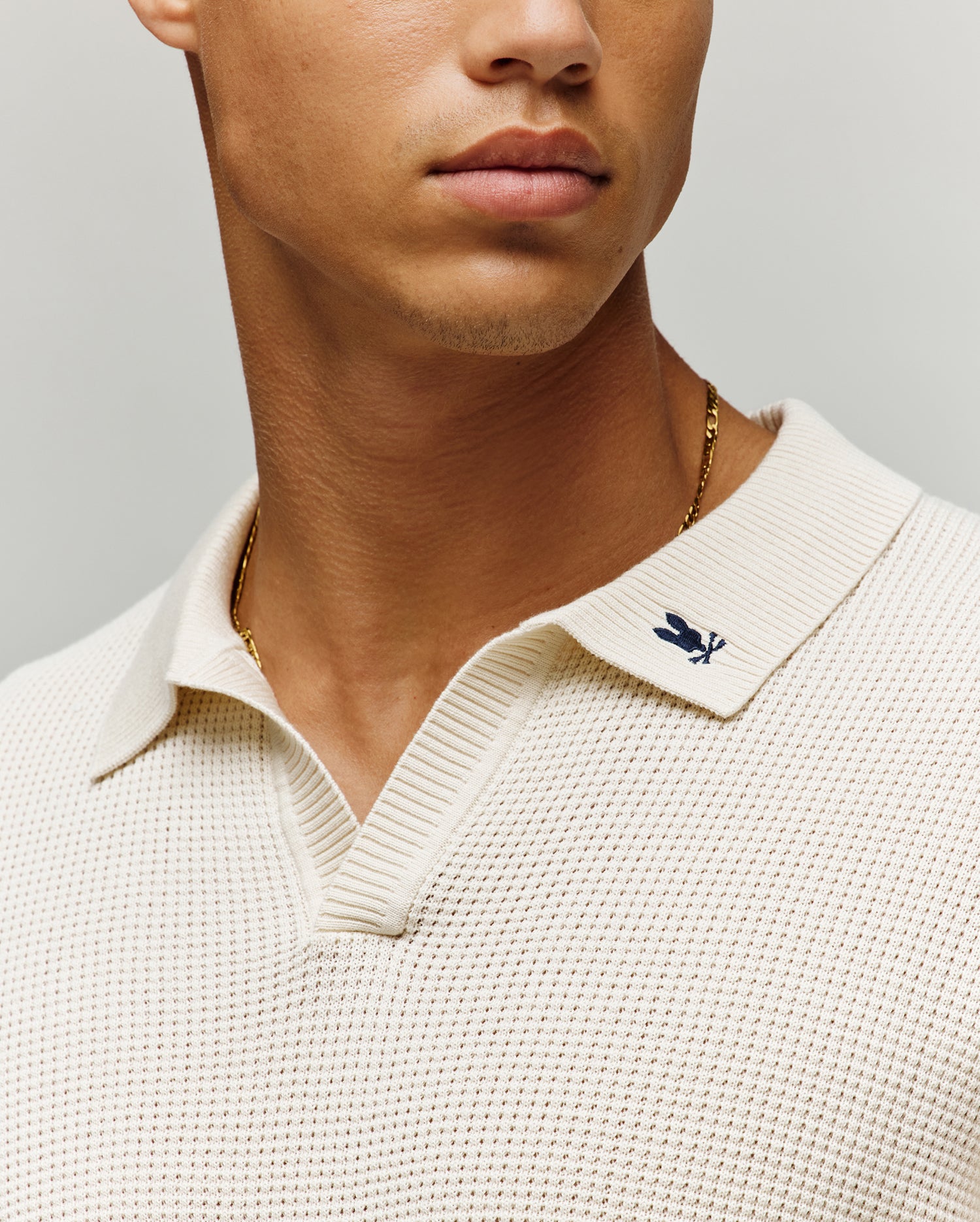 Mens Lochlan Oversized Johnny Collar Polo in cream textured knit, featuring a small embroidered dark blue Psycho Bunny skull logo on the left collar.