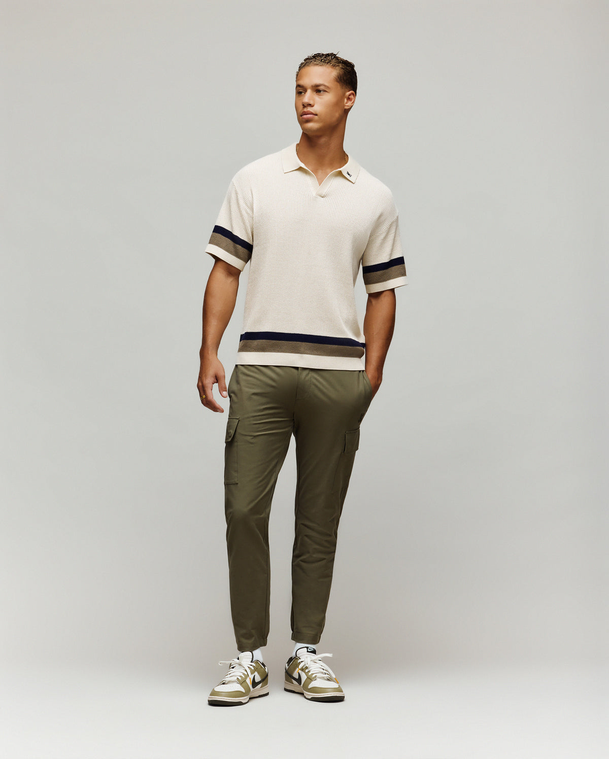 Mens Lochlan Oversized Johnny Collar Polo in cream waffle knit, featuring navy and olive stripes on sleeves and hem, with a small embroidered Psycho Bunny skull logo on the left chest.