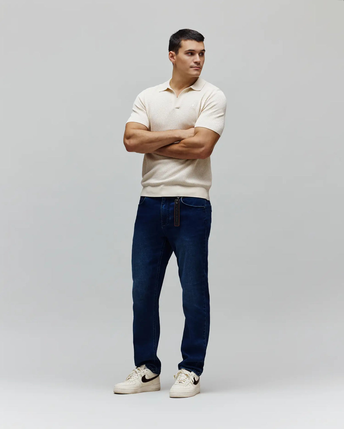 Mens Devon Knit Polo in ecru, featuring a textured knit fabric, classic fit, two-button placket, and a small white embroidered Psycho Bunny skull logo on the left chest.