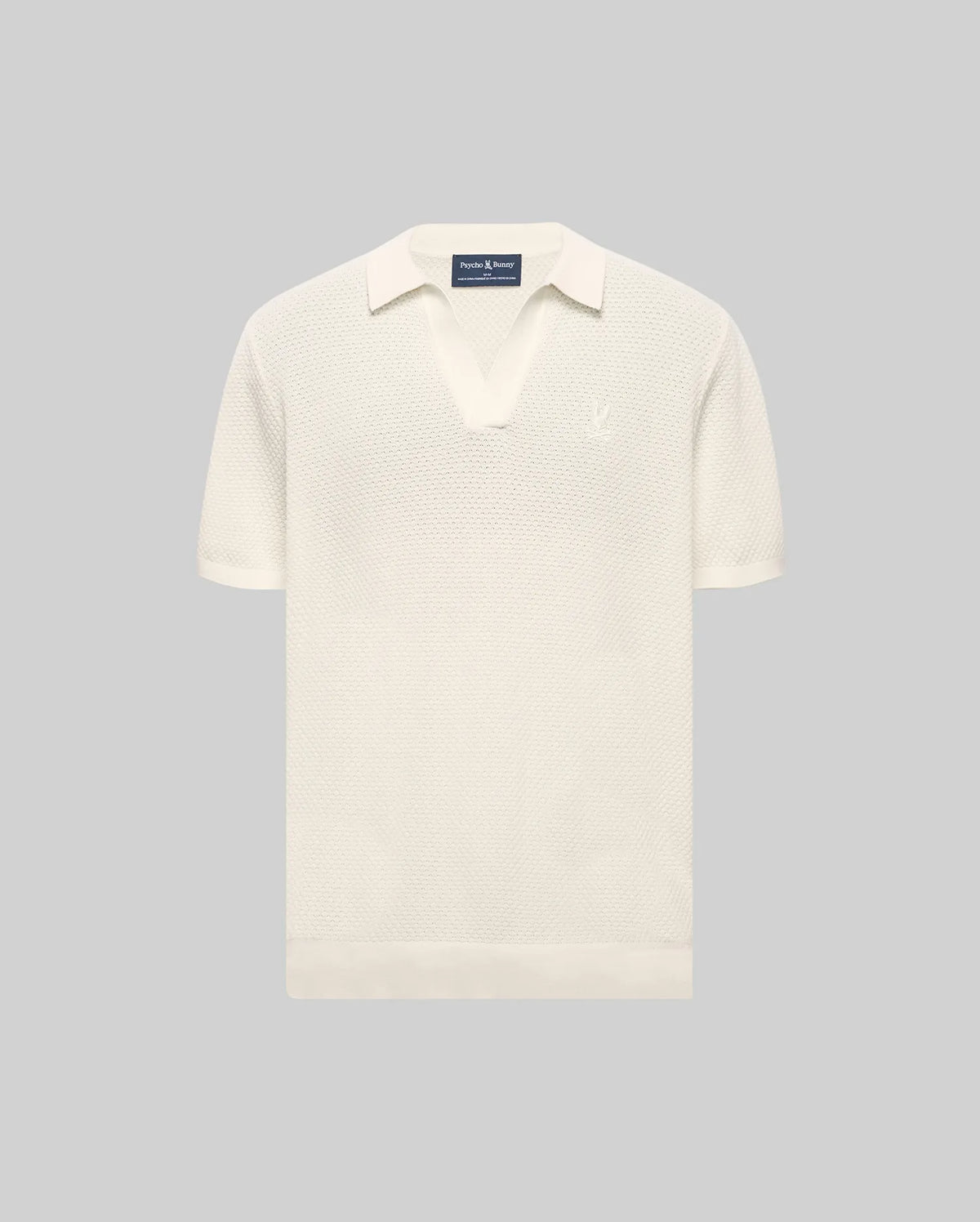 Cream Mens Devon Knit Polo with a textured knit fabric, open collar, short sleeves, ribbed cuffs and hem, featuring a small, tonal embroidered Psycho Bunny skull logo on the left chest.