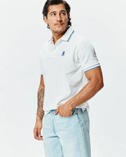 Mens Brad Pique Polo: White classic fit pique polo with blue tipped collar and cuffs, featuring a small embroidered blue Psycho Bunny skull logo on the left chest. (1)