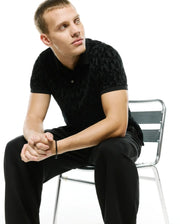 Men's Angus Flocked Polo, a classic fit black polo shirt featuring a subtle, tonal black flocked geometric pattern throughout, providing a luxurious, soft texture. (3)