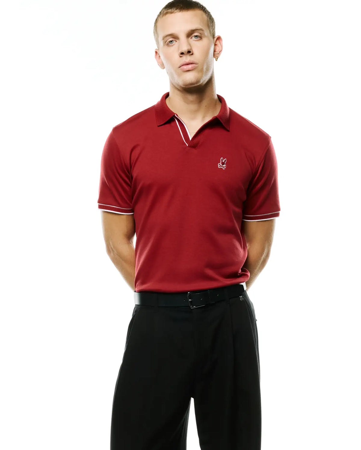 Men's Nasser Johnny Collar Polo, deep red pique, classic fit. Johnny collar with white tipping, white tipped short sleeves, and a small white embroidered Psycho Bunny skull logo on the left chest. (3)