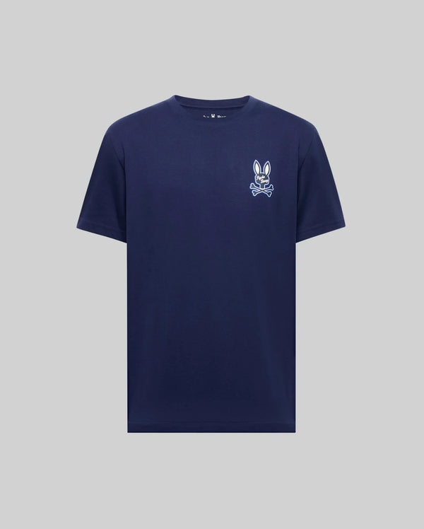 The Psycho Bunny MENS DEREK CHEST GRAPHIC TEE (MT0200009) is a regular fit, navy blue Pima cotton short-sleeve t-shirt with a small white bunny and bowtie print on the left chest, shown against a light gray background.
