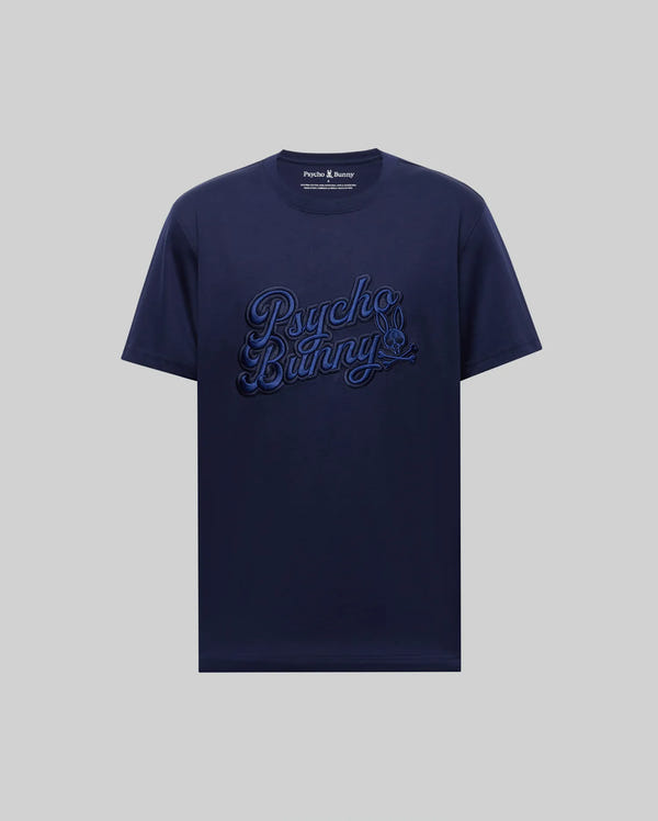 The MENS ELIAS GRAPHIC TEE - MT0200047 by Psycho Bunny is a navy blue Pima cotton t-shirt with "Psycho Bunny" in large, textured script across the chest, shown on a light grey background.