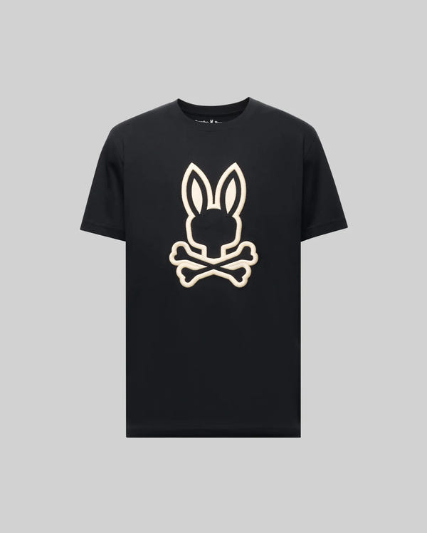 The Psycho Bunny MENS NICHOLAS EMBROIDERED TEE (MT0200054) is a black shirt featuring a large embroidered bunny head with upright ears above crossed bones, creating a playful skull-and-crossbones effect on a plain gray background.