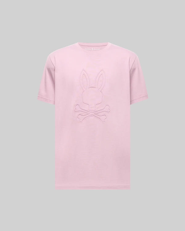 The Psycho Bunny MENS REMY GRAPHIC TEE (MT0200059) is a light pink Pima cotton shirt featuring an embossed bunny logo above crossed bones, shown on a plain gray background.