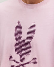Close-up of the Psycho Bunny MENS GRANT BUNNY GRAPHIC TEE - MT0200081, made in Peru from soft Pima cotton in light pink, with a dark purple striped bunny head and crossed bones graphic on the chest.