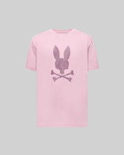 The Psycho Bunny MENS GRANT BUNNY GRAPHIC TEE - MT0200081 is a pink Pima cotton t-shirt featuring a rabbit head above crossed bones and dark stripes on the front, shown on a plain gray background.