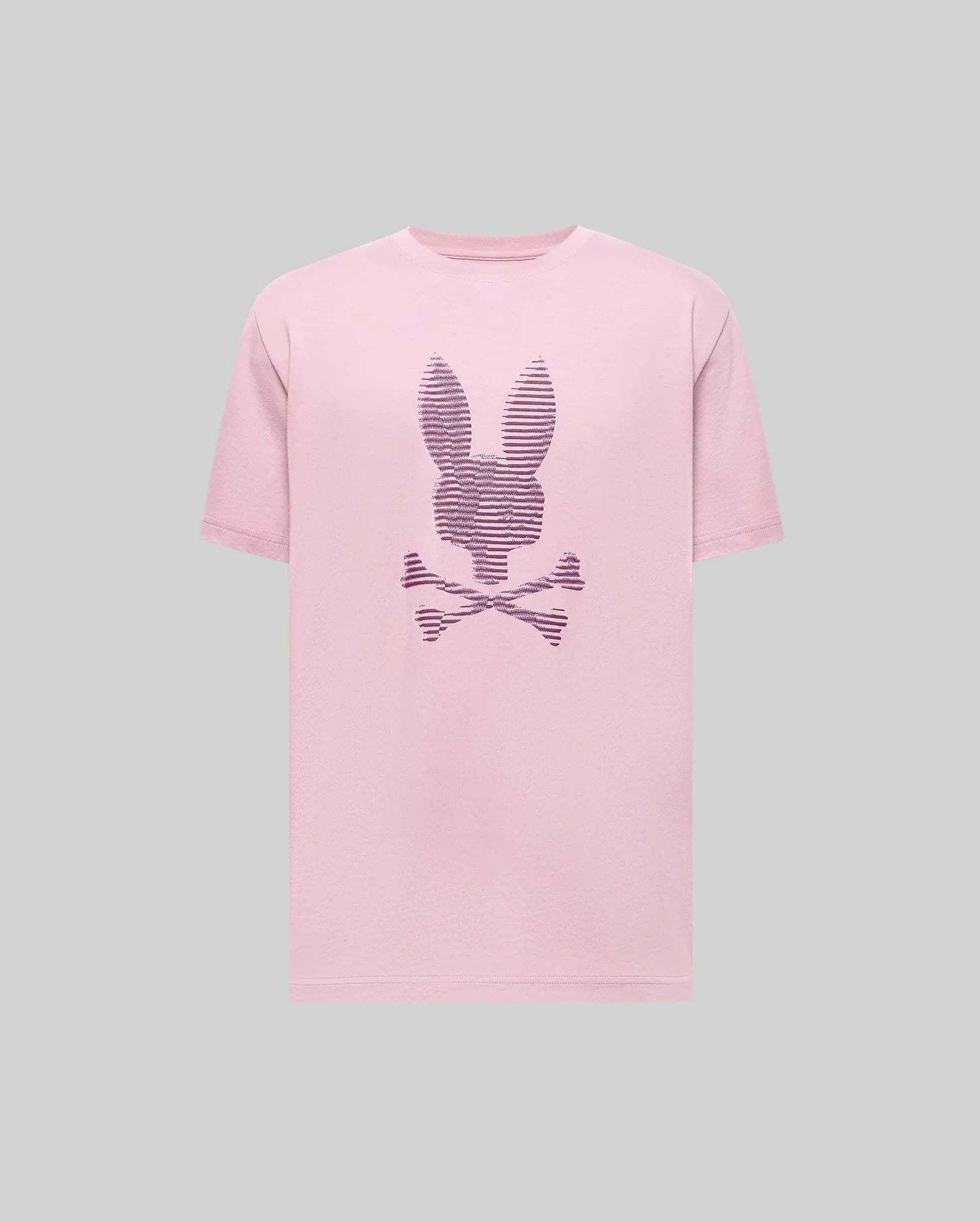 The Psycho Bunny MENS GRANT BUNNY GRAPHIC TEE - MT0200081 is a pink Pima cotton t-shirt featuring a rabbit head above crossed bones and dark stripes on the front, shown on a plain gray background.