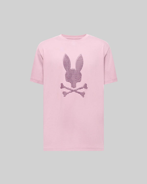 The Psycho Bunny MENS GRANT BUNNY GRAPHIC TEE - MT0200081 is a pink Pima cotton t-shirt featuring a rabbit head above crossed bones and dark stripes on the front, shown on a plain gray background.