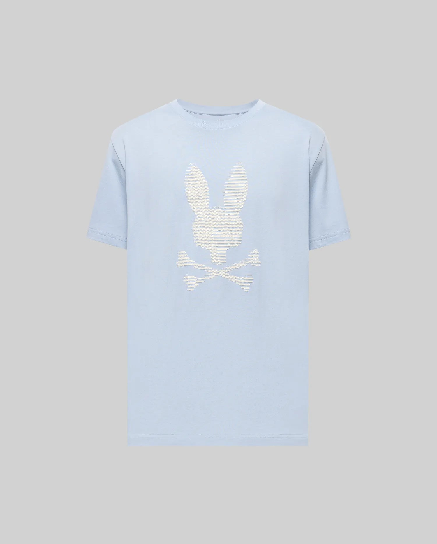 The Psycho Bunny MENS GRANT BUNNY GRAPHIC TEE (MT0200081) features a light blue Pima cotton build with a bold white bunny head over crossed bones graphic on the chest, set against a plain grey background.