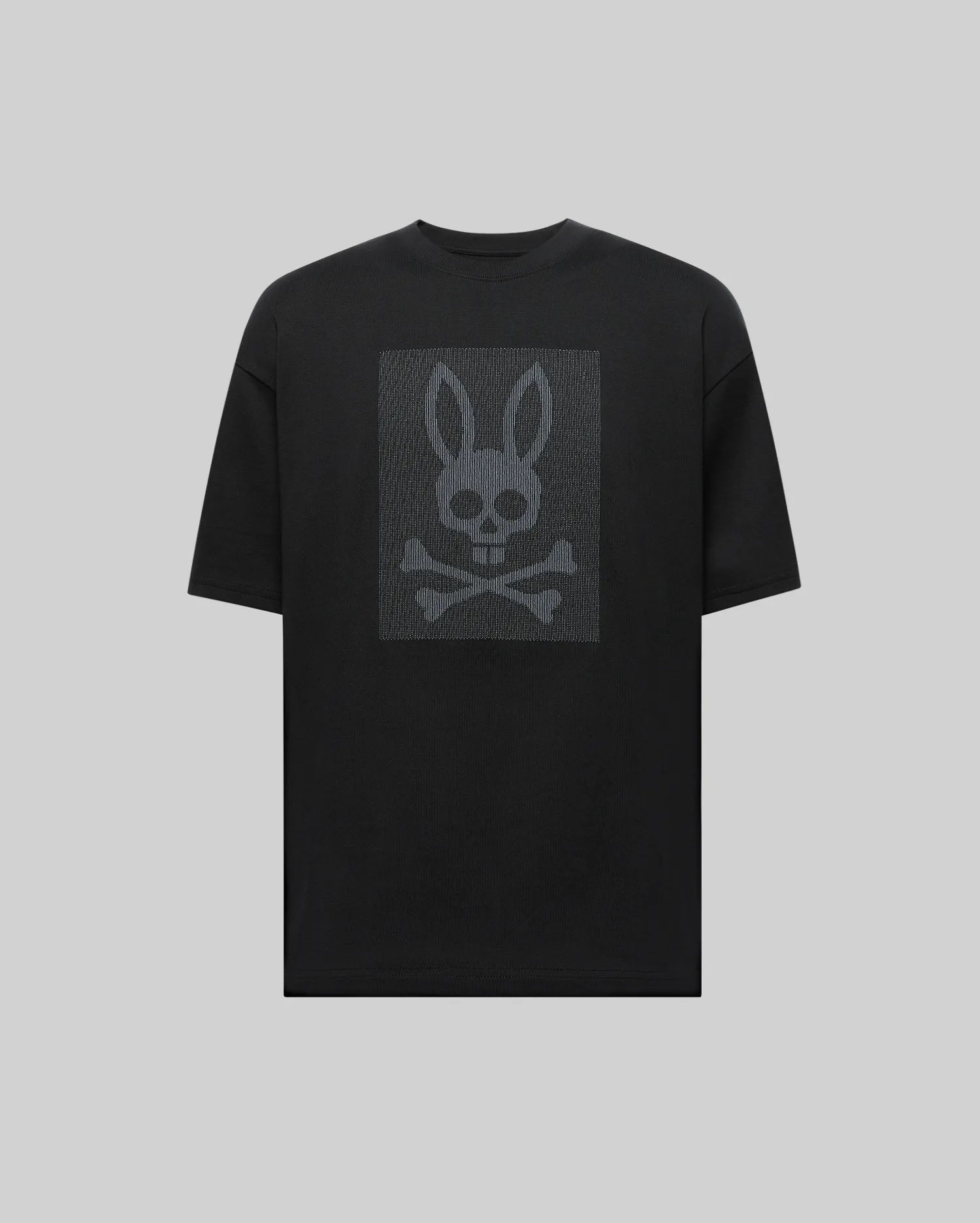 The Psycho Bunny MENS REECE OVERSIZED TEE (MT0200082) is a black relaxed fit shirt with a dark gray bunny skull and crossbones graphic on the chest, presented on a light gray background.