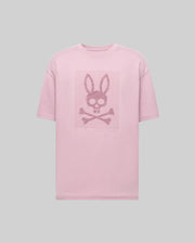 The Psycho Bunny MENS REECE OVERSIZED TEE (MT0200082) is a light pink Pima cotton shirt with a dark pink bunny-eared skull and crossbones graphic on the chest, shown on a plain gray background.