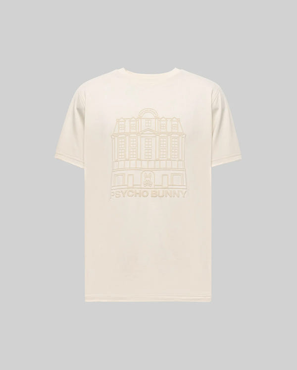 The Psycho Bunny MENS REDFORD GRAPHIC TEE (MT0200092) is a plain beige Pima cotton shirt with a subtle building line drawing and "PSYCHO BUNNY" text on the back, shown here against a light gray background.