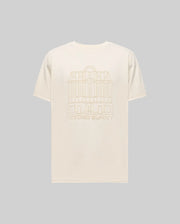 The Psycho Bunny MENS REDFORD GRAPHIC TEE (MT0200092) is a plain beige Pima cotton shirt with a subtle building line drawing and "PSYCHO BUNNY" text on the back, shown here against a light gray background.