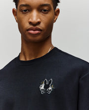A person wearing the Psycho Bunny MENS AUGUSTE OVERSIZED TEE (MT0200104), featuring a small embroidered Bunny logo above two crossed carrots on the chest, ideal for a laidback style.