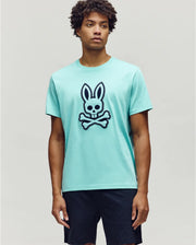 Mens Gage Graphic Tee, an aqua classic fit soft jersey t-shirt featuring a large black and white embroidered Psycho Bunny skull and crossbones logo with zig-zag stitching centered on the chest.