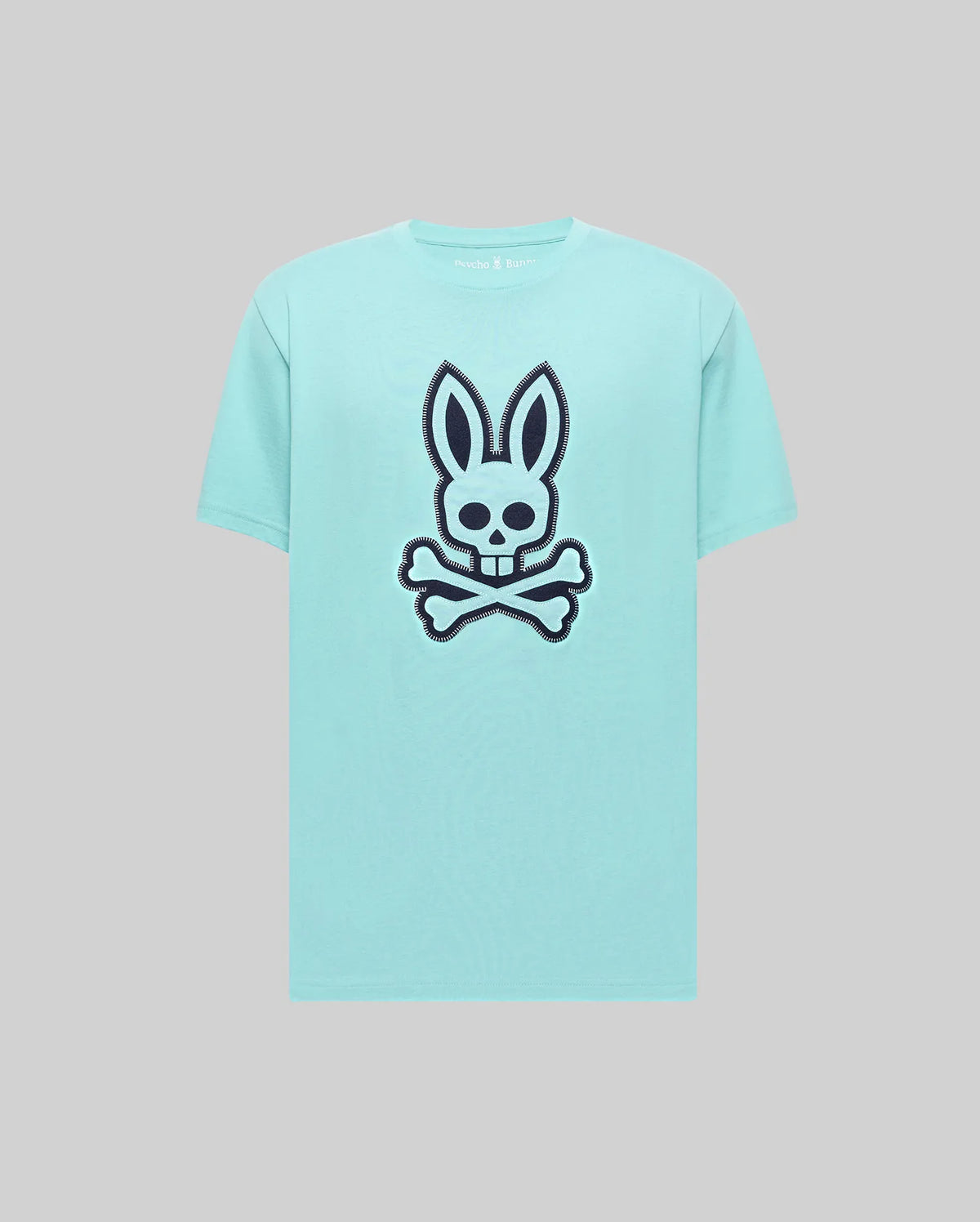 Mens Gage Graphic Tee, a classic fit light aqua jersey t-shirt featuring a large navy bunny skull and crossbones graphic on the chest and small Psycho Bunny text logo on the back neckline.