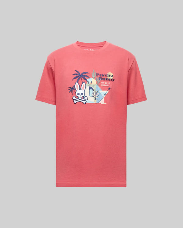 The MENS SHANE GRAPHIC TEE - MT0200175 by Psycho Bunny is a coral pink Pima cotton shirt with a cartoon bunny and crossbones, palm trees, city graphics, and "Psycho Bunny" text on the front, shown on a gray background.