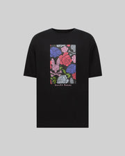 The Psycho Bunny MENS ROWEN OVERSIZED TEE (MT0200194) features a relaxed fit with a vibrant floral bunny logo in pink, purple, red, and blue on the chest, plus "Psycho Bunny" text below the graphic.