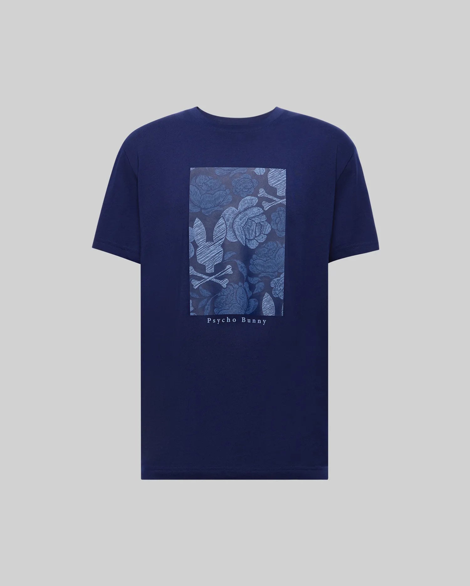 The MENS ROWEN OVERSIZED TEE (MT0200194) by Psycho Bunny is a navy blue Pima cotton shirt with a light blue rectangular floral and leaf graphic on the back, "Psycho Bunny" printed below, and a relaxed, oversized fit for comfort.