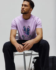 Mens Olivier Graphic Tee, lavender, classic fit, soft jersey, featuring a large center chest Psycho Bunny skull logo with a purple and blue digital camouflage pattern.