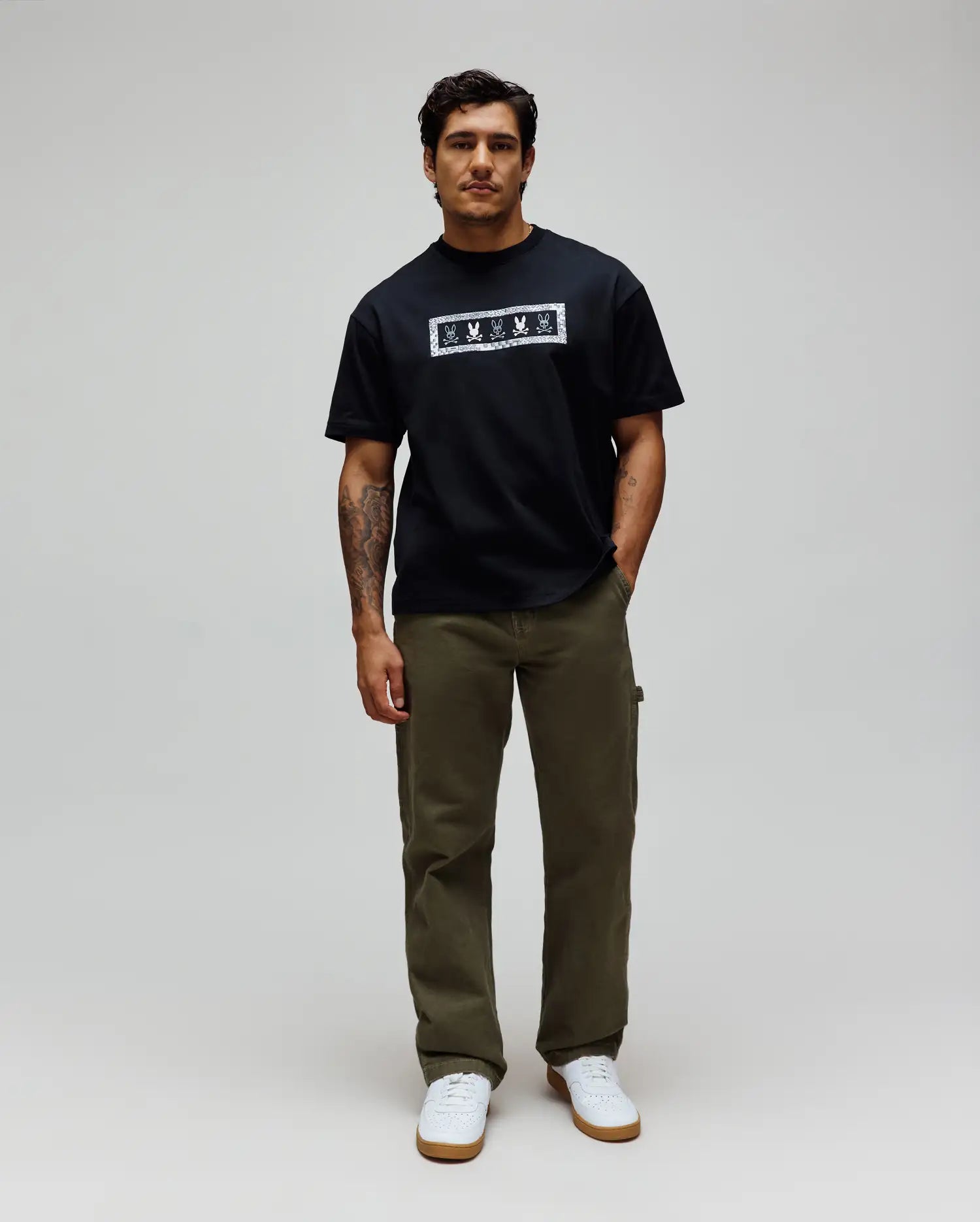 Mens Olivier Oversized Tee in black jersey, featuring a bold white rectangular chest graphic with an intricate bandana-style border and repeated Psycho Bunny skull logos.