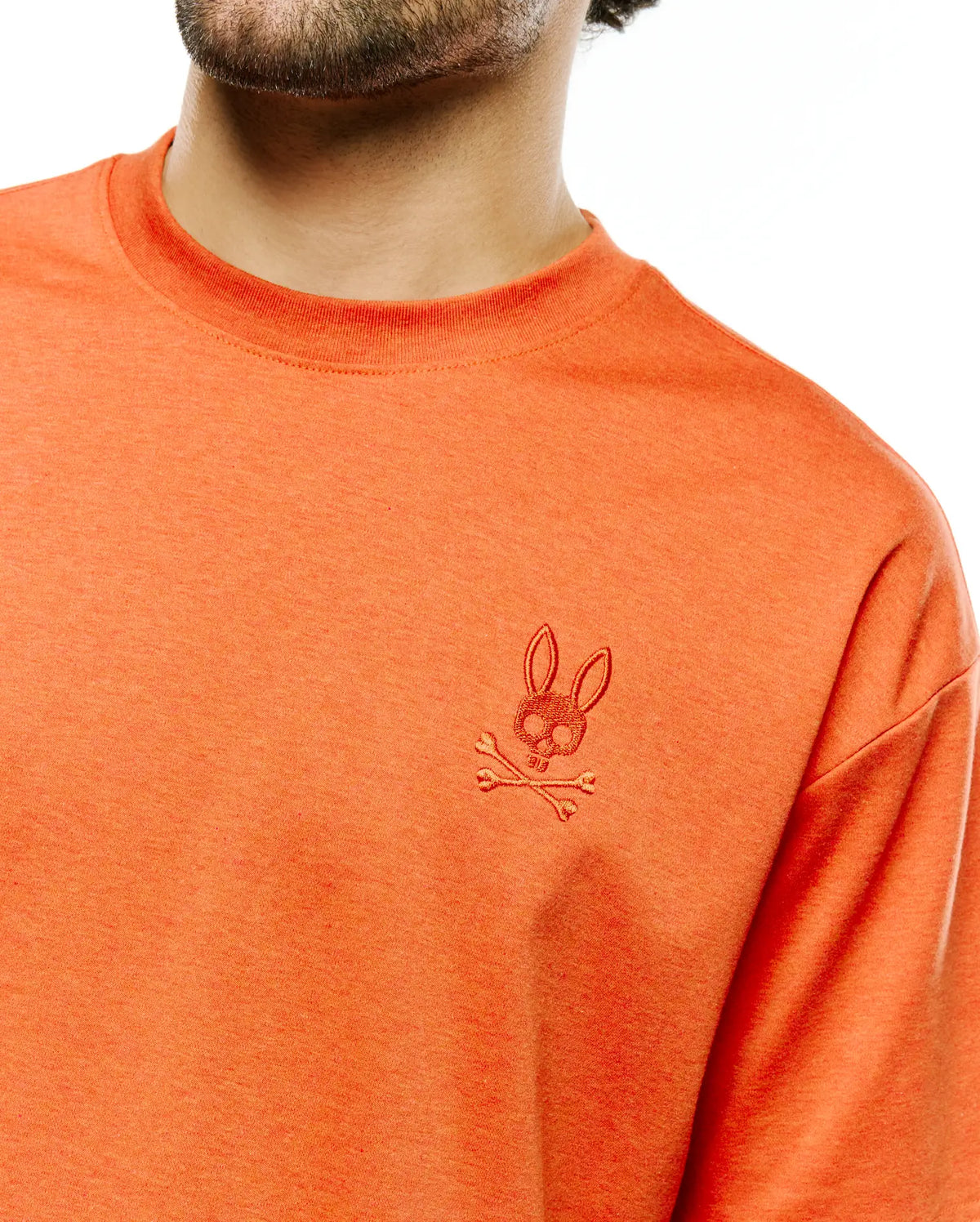 Men's Oscar Oversized Tee in heathered orange jersey knit, featuring a small, tonal embroidered Psycho Bunny skull and crossbones logo on the left chest. (3)