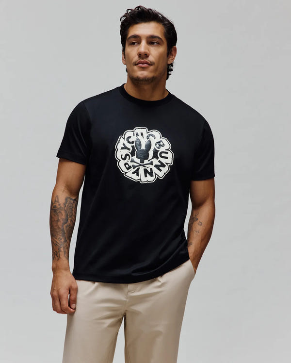 Mens Toby Graphic Tee, a black classic fit jersey t-shirt featuring a large distressed white circular Psycho Bunny skull logo and text graphic centered on the chest.