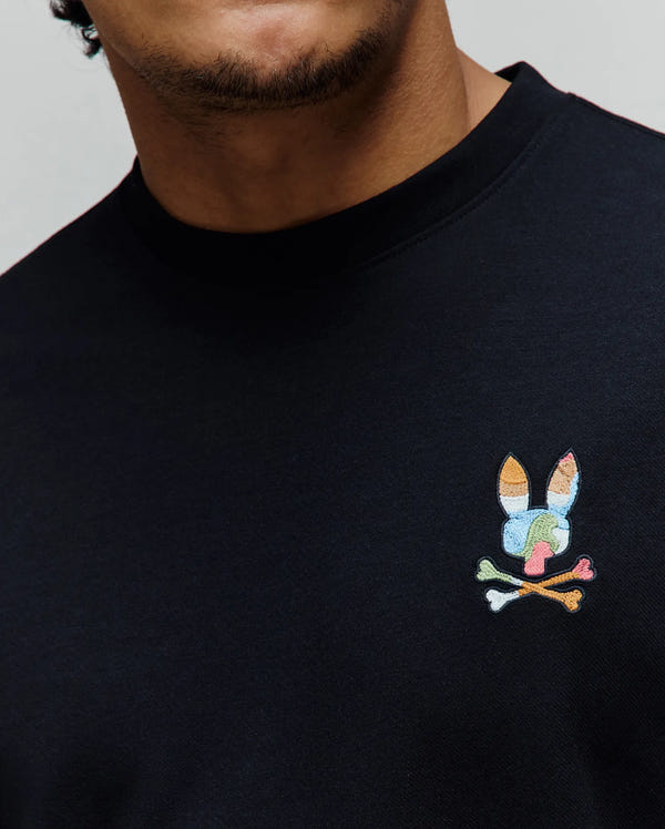 Mens Ara Oversized Tee, black smooth jersey knit with a small, left chest embroidered multicolor Psycho Bunny skull logo featuring orange, blue, green, pink, and white accents.