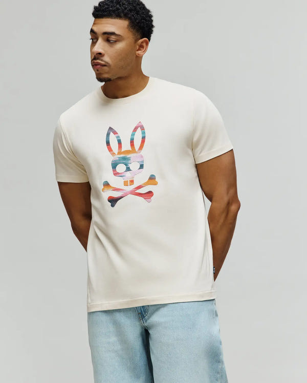 Mens Raphael Graphic Tee, a classic fit cream jersey t-shirt featuring a large, vibrant multi-color striped Psycho Bunny skull and crossbones graphic on the chest.