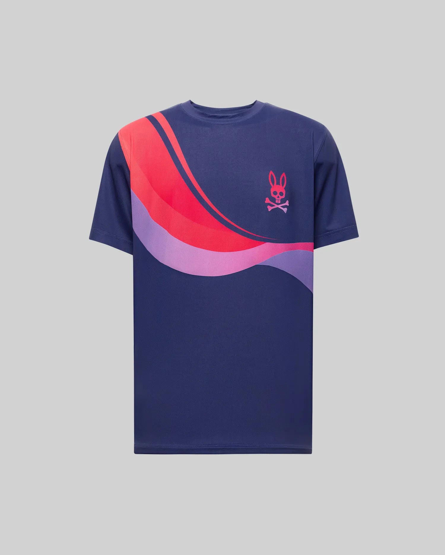The Psycho Bunny MENS OFFICIAL US OPEN AVERY NET PERFORMANCE TEE (MT0200273) is a navy blue, slim-fit shirt with pink and purple wavy stripes across the chest and shoulder, plus a small pink bunny skull logo on the left side.