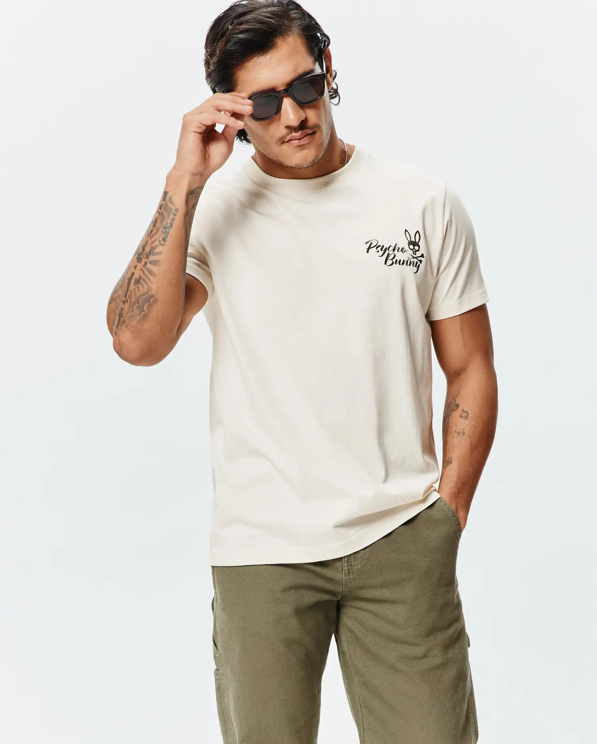Mens Colin Back Graphic Tee, a premium soft cream jersey t-shirt with a classic fit, featuring a small embroidered black Psycho Bunny skull logo on the left chest. (2)