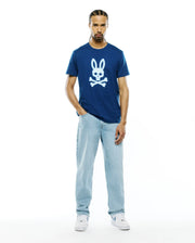 Mens Emmanuel Graphic Tee, a navy blue classic fit jersey t-shirt featuring a large white graphic Psycho Bunny skull logo centered on the chest. (5)