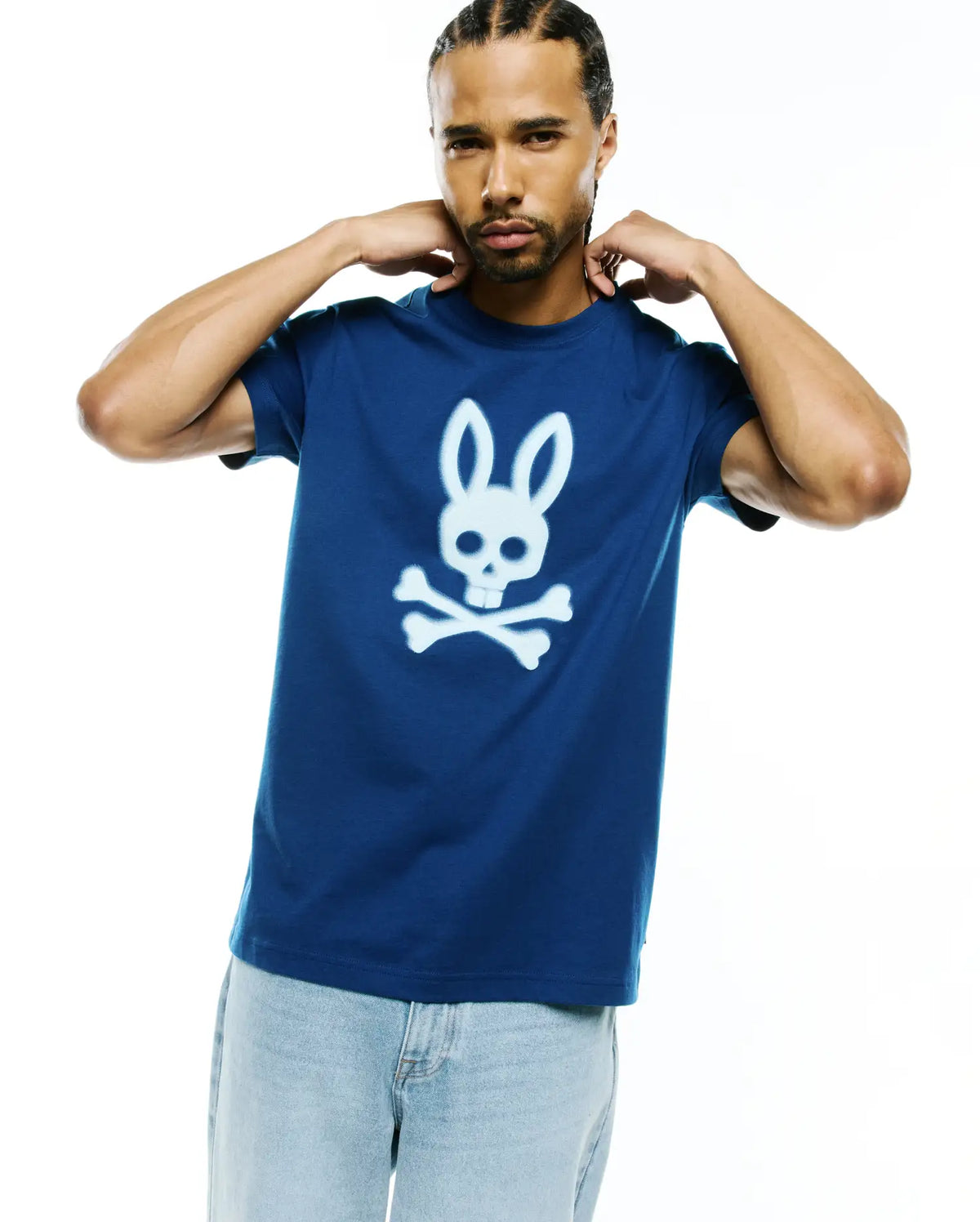 Mens Emmanuel Graphic Tee, a classic fit deep blue jersey t-shirt featuring a large, central white Psycho Bunny skull and crossbones graphic with a spray-paint effect. (2)