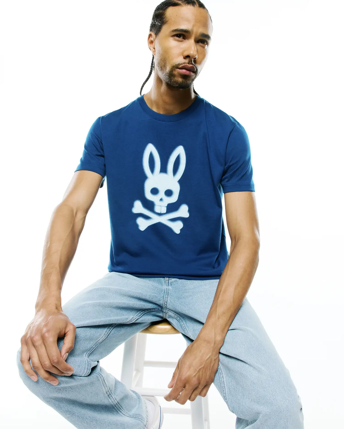 Mens Emmanuel Graphic Tee in deep blue, featuring a classic fit and smooth jersey fabric. A large, centered white Psycho Bunny skull and crossbones graphic is prominently displayed on the chest. (4)