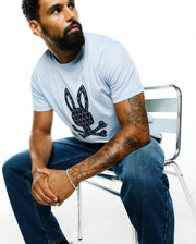 Sky blue Mens Jaden Appliqué Graphic Tee, classic fit, with a large textured navy Psycho Bunny skull logo on the chest, filled with mini bunny patterns. (4)