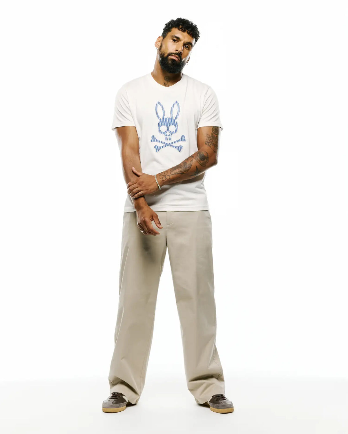 Mens Stan Pima Cotton Graphic Tee, an off-white classic fit t-shirt featuring a large, central textured blue Psycho Bunny skull and crossbones graphic on smooth Pima cotton jersey. (4)