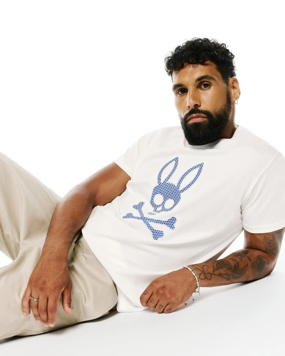 Mens Stan Pima Cotton Graphic Tee, a classic fit white premium Pima cotton jersey t-shirt featuring a large, central blue checkered Psycho Bunny skull logo. (3)