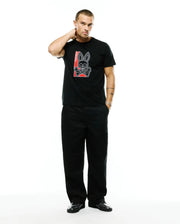 Men's Lowell Graphic Tee, a black classic-fit jersey t-shirt featuring a large chest print of the iconic Psycho Bunny skull and crossbones logo in white with a red rectangular background and vertical Psycho Bunny text. (5)