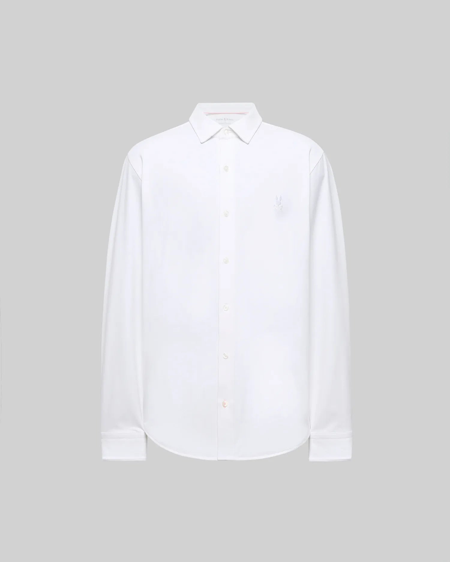 The Psycho Bunny MENS JIM JERSEY KNIT SHIRT (MT0300067) is a long-sleeved, white, athletic-fit shirt with a collar and a subtle embroidered logo on the upper left chest, shown on a plain light gray background.