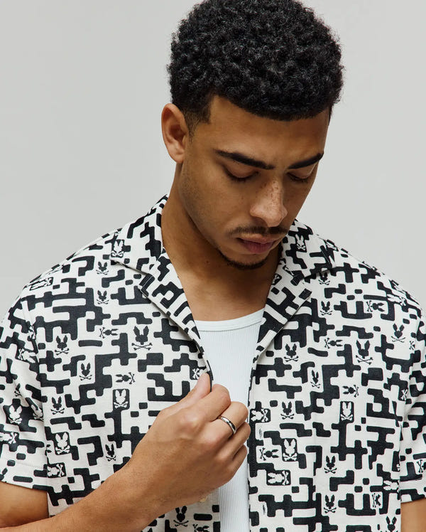Mens Josh Jacquard Shirt, a black and white all-over pixelated geometric pattern with integrated small Psycho Bunny skull logos, featuring a relaxed fit and short sleeves.